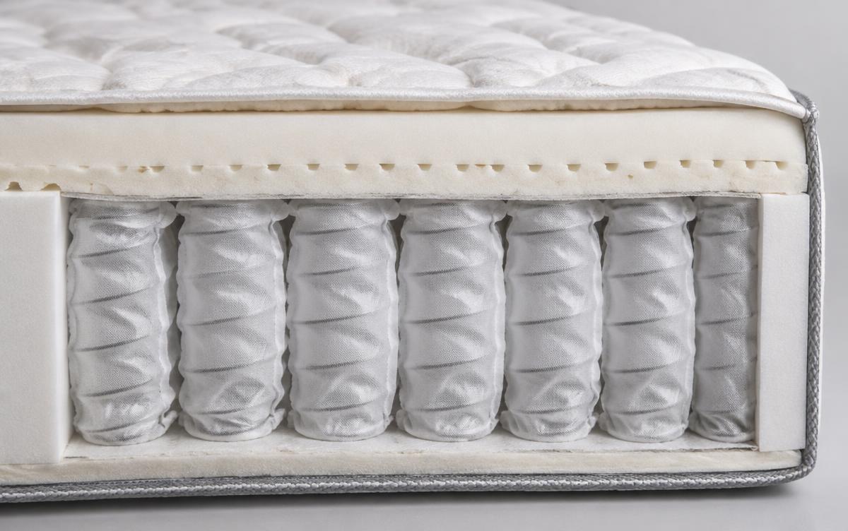 Doorsnede van een pocketvering matras met losse veren in stoffen zakjes onder een comfortlaag